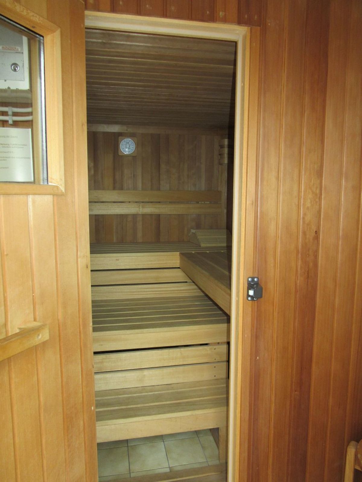 Un sauna con bancos de madera y piso de baldosas.