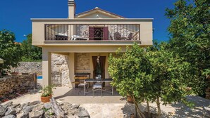 A two-story house with a balcony, stone walls, and a patio area with outdoor furniture. - Beautiful home in Krk with private swimming pool, can be inside or outside (Krk)