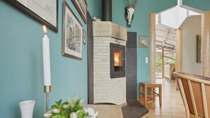 Un intérieur chaleureux avec une cheminée, des tableaux encadrés et un banc en bois.