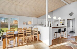 A modern kitchen with white cabinets, a central island, and bar stools. - Nice home in Toftlund with sauna (Toftlund)