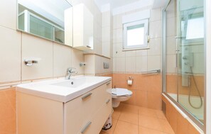 A modern bathroom with a sink, toilet, and glass shower enclosure. - 3 bedroom awesome apartment in Kastel Kambelovac (Kastel Kambelovac)