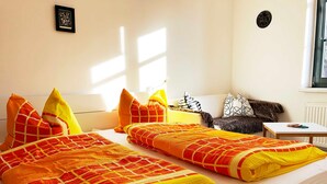 Een hotelkamer met twee bedden, een bank en een kleine tafel.