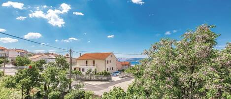 A residential area with houses, a clear sky, and a view of the sea.