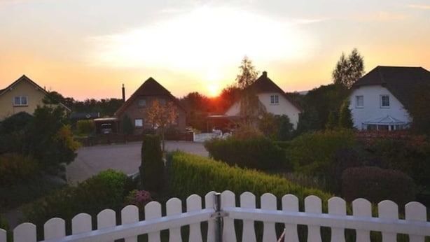 Un quartier résidentiel avec des maisons et une clôture blanche en bois.