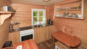 A compact kitchen with wooden walls, a stove, sink, and a small dining table. - 2 bedroom beautiful home in Balestrand (Balestrand)