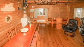 A wooden cabin interior with a dining table, chairs, a fireplace, and a leather armchair. - 2 bedroom beautiful home in Balestrand (Balestrand)