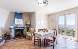 A dining area with a fireplace, a table set for four, and a view of the outdoors.
