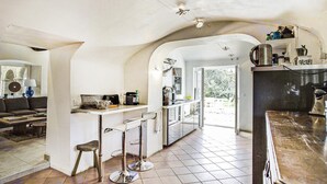 Une cuisine avec un coin bar, une table à manger et un canapé.