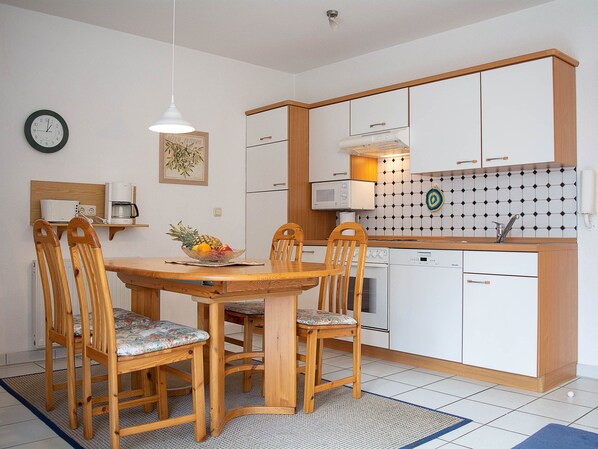 A compact kitchen with wooden cabinets, a microwave, and a sink. - Reriker Straße RER20-03. - Reriker Straße 20 Whg. 03 (Kühlungsborn)