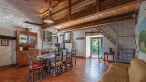 A rustic interior with exposed wooden beams, a dining area with a table and chairs, a kitchen with modern appliances, and a staircase leading to an outdoor area. - Gorgeous home in Pieve S. Stefano AR (Pieve S. Stefano AR)