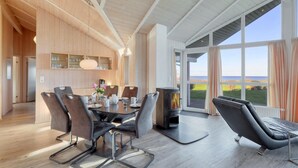 A modern dining area with a large table, chairs, and a wood-burning stove. - Amazing home in Schönhagen with sauna (Schönhagen)