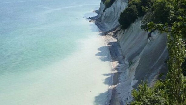 Eine Küstenlandschaft mit Strand und Klippen.