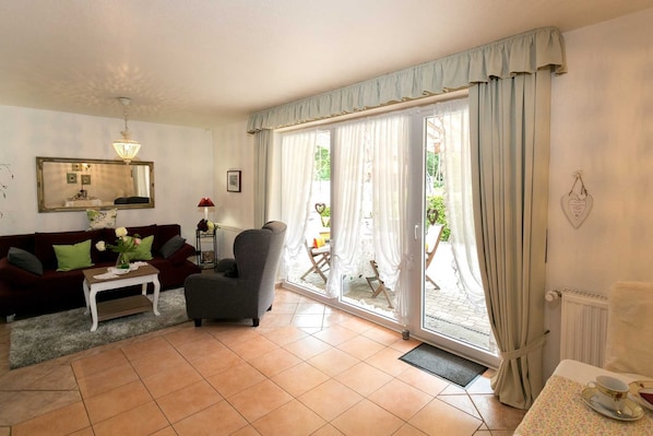 Una sala de estar con un sofá, un sillón y una mesa con un florero.