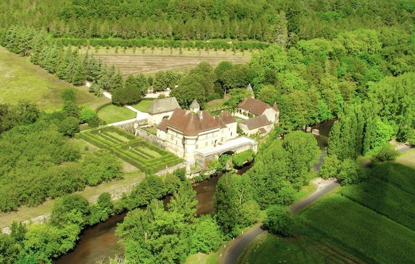 A large, historic building surrounded by lush greenery and a river. - Luxurious home in Gardonne with private swimming pool, can be inside or outside (Gardonne)
