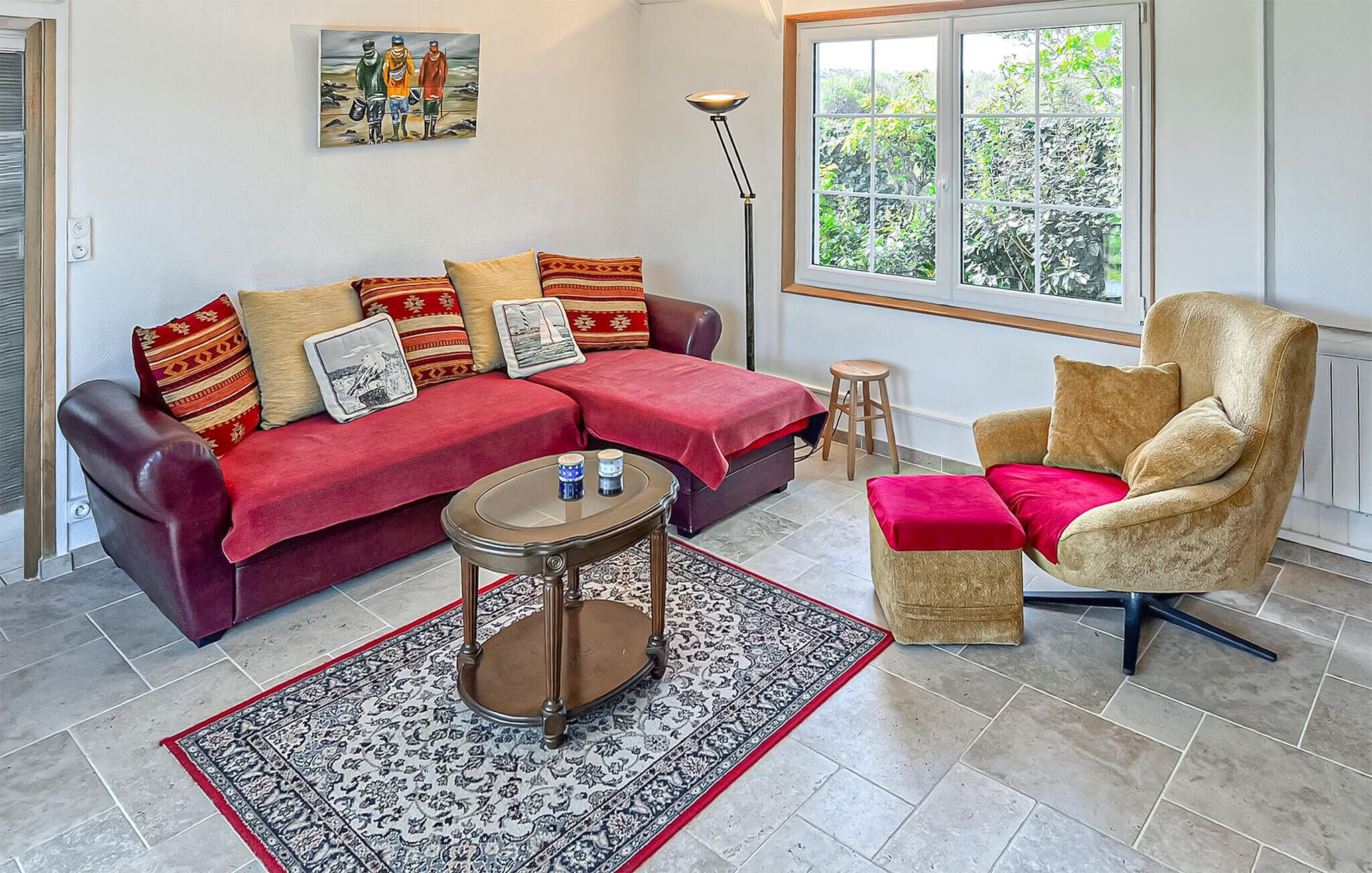 Ein Wohnzimmer mit Sofa, Sessel, Couchtisch und Teppich.