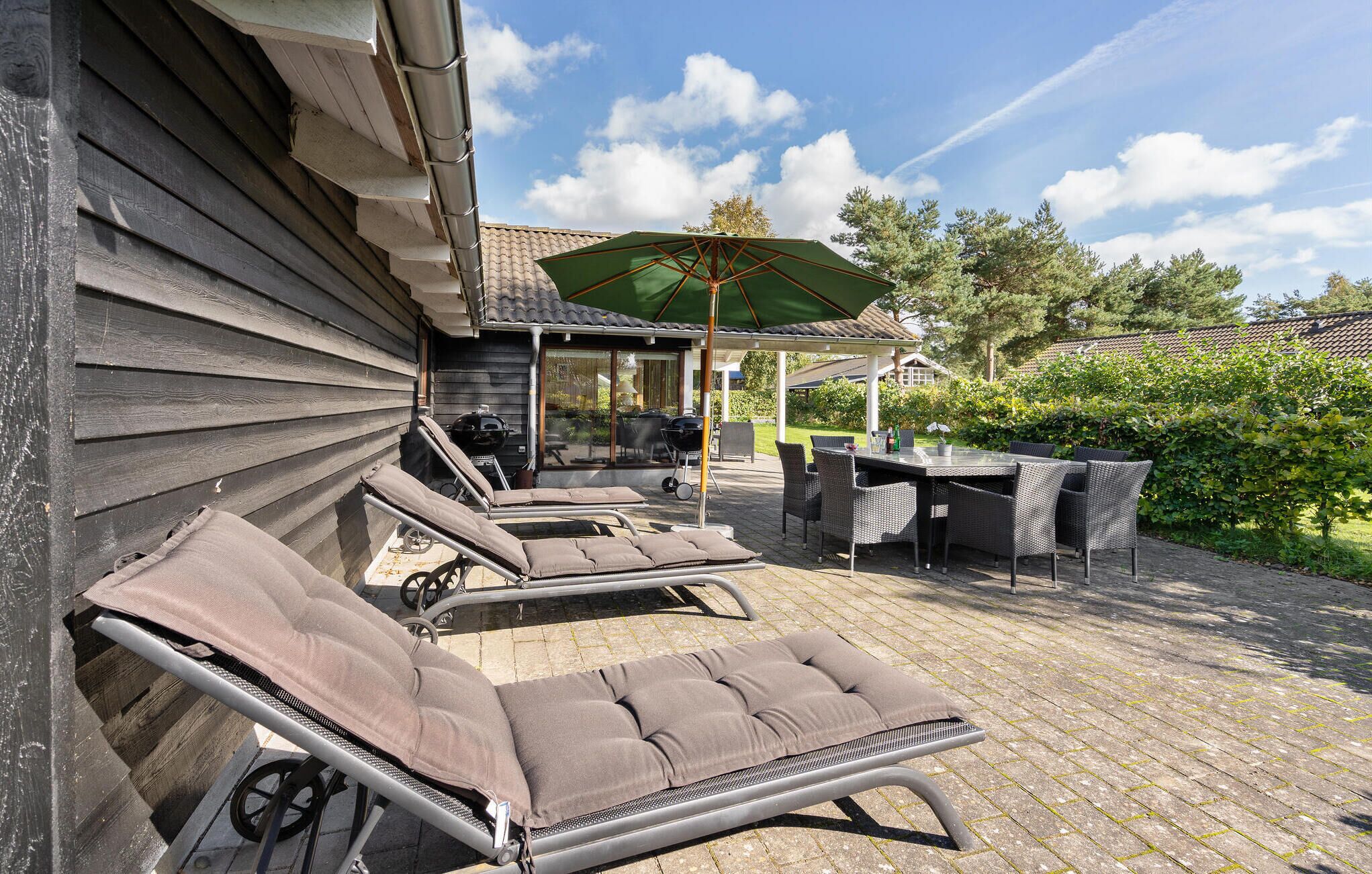 Patiolla on lepotuoleja, pöytä ja grillauspaikka.