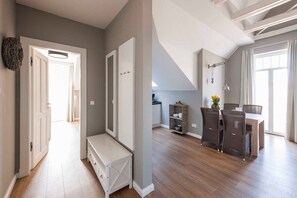 A spacious living area with a dining table and chairs, a bench, and a small kitchen area.