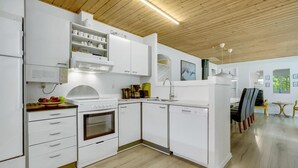 A modern kitchen with white cabinetry, a built-in oven, and a microwave. - Lovely home in Oksbøl with sauna (Oksbøl)
