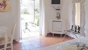 Une chambre à coucher avec un lit, une chaise, une télévision et une fenêtre.