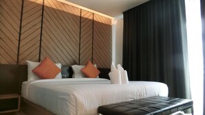 A modern hotel room with a large bed, a bench, and a wooden headboard. - Irin Beach Cha - am (Cha-am)