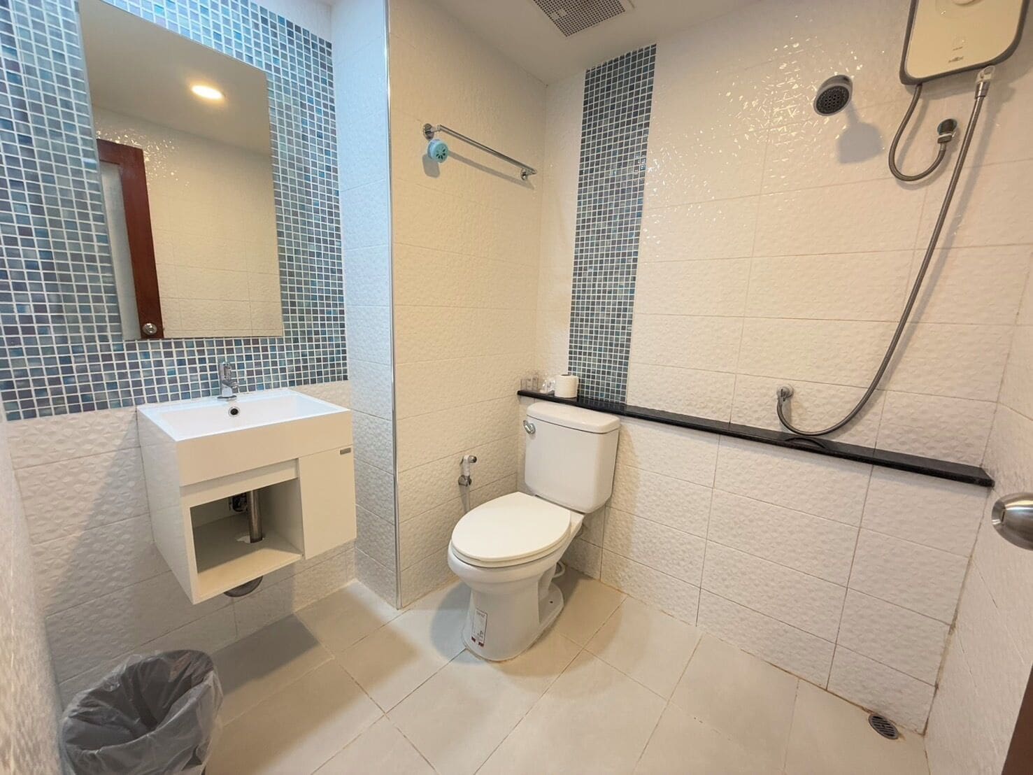 A bathroom with a white sink, toilet, and shower.