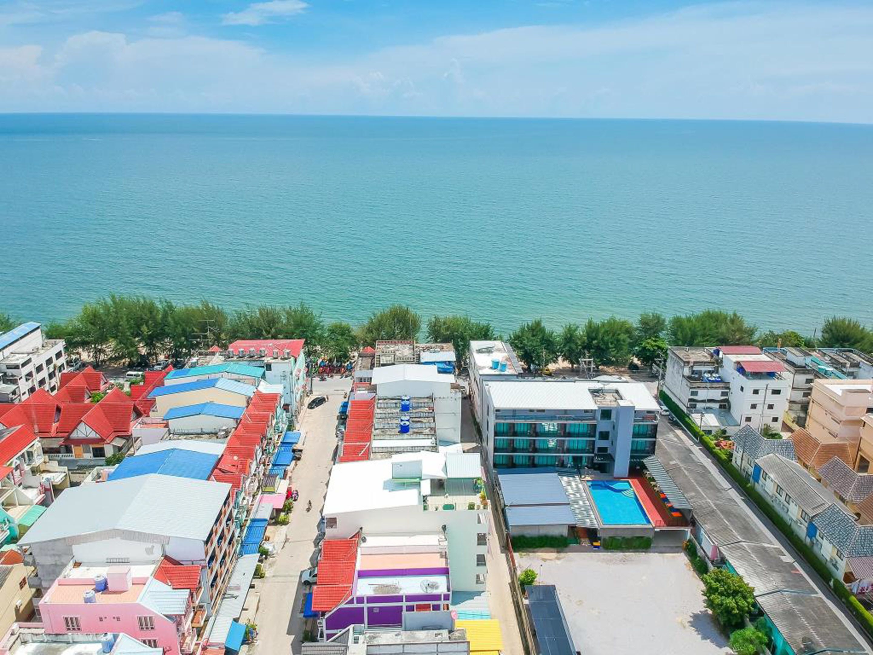 A coastal town with colorful buildings, a clear view of the sea, and a mix of residential and commercial structures.
