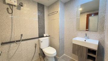 Un baño moderno con inodoro, ducha y lavamanos.