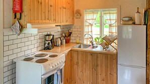 Une cuisine équipée d’une cuisinière, d’un évier et d’un réfrigérateur.