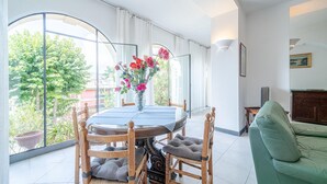 A dining area with a round table, chairs, and a vase of flowers. - Lovely apartment in Rapallo GE with WiFi (Rapallo GE)