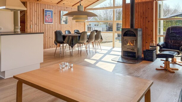 A wooden interior with a dining area, a fireplace, and large windows. - Nice home in Sydals with sauna (Sydals)