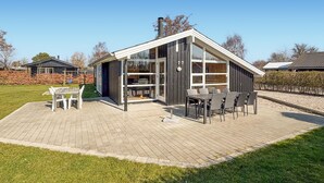A modern house with a patio, a dining area, and a large window. - Nice home in Sydals with sauna (Sydals)