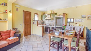 Un accogliente soggiorno con divano e angolo pranzo con tavolo apparecchiato per due persone.