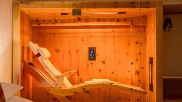 A wooden sauna with a wooden bench and a control panel.