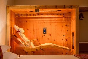 A wooden sauna with a wooden bench and a control panel.