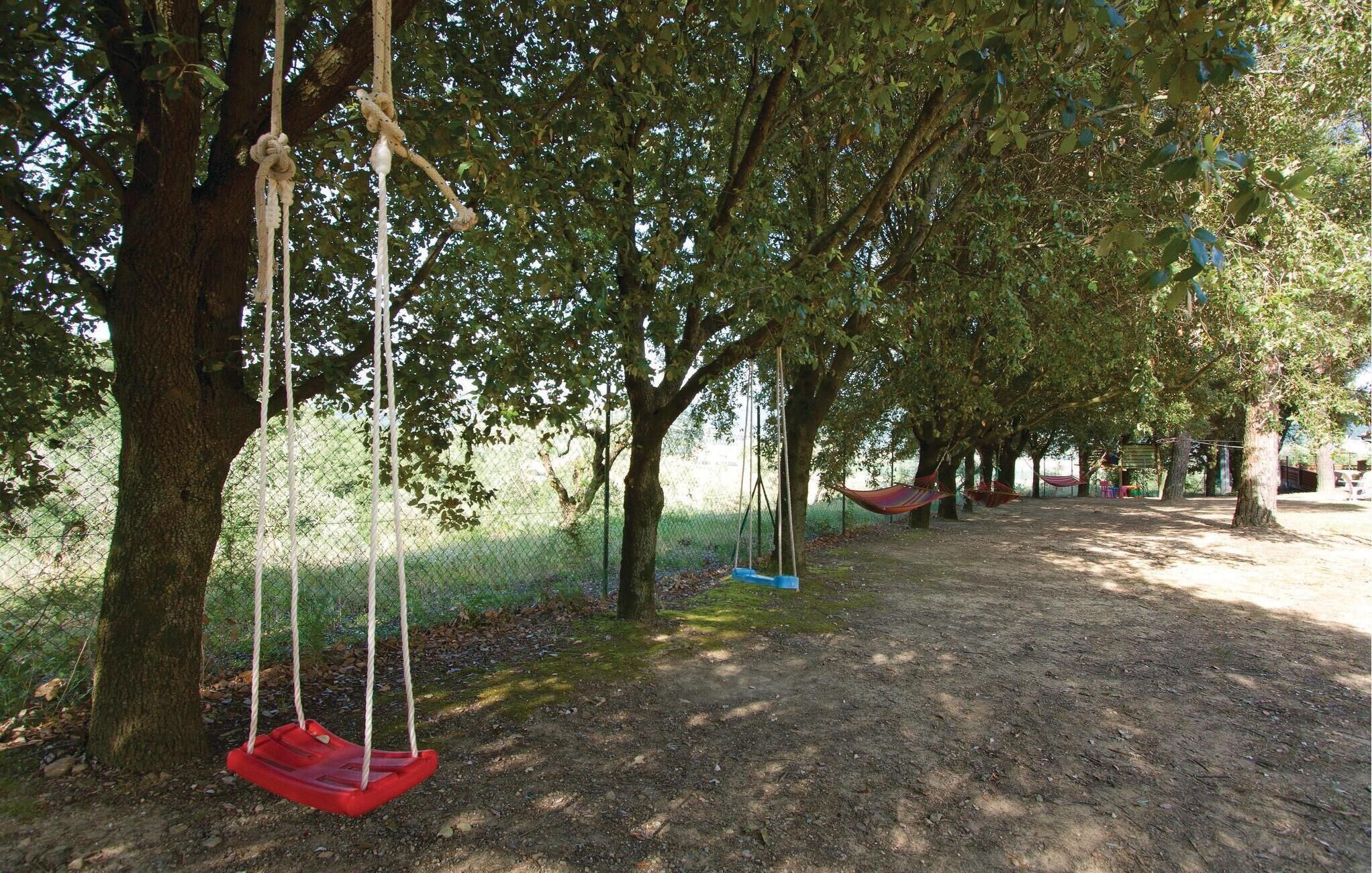 A park with swings and a fenced area.