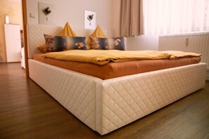 A neatly made bed with a quilted headboard and a mattress with a quilted edge.