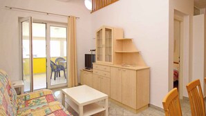 Ein kleines Zimmer mit einem Bett, einem Tisch, einem Schrank und einem Stuhl.