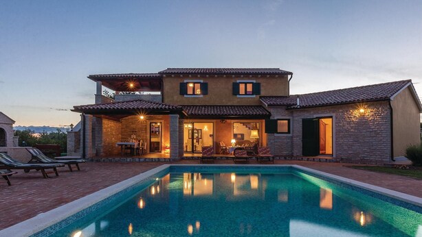 Une maison à deux étages avec une piscine, un espace extérieur aménagé pour s’asseoir et une terrasse.