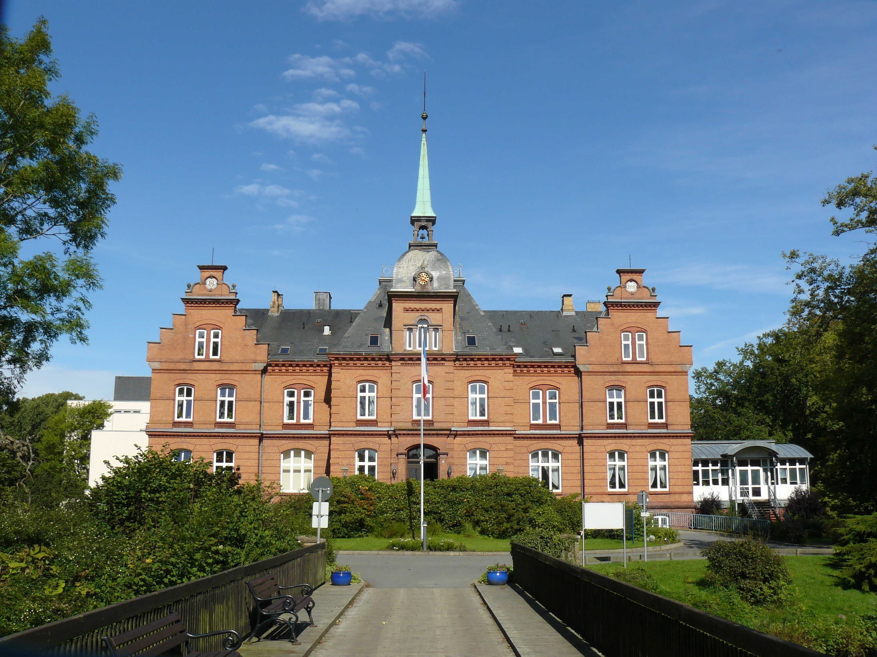 A large, historic building with a prominent tower and multiple windows.