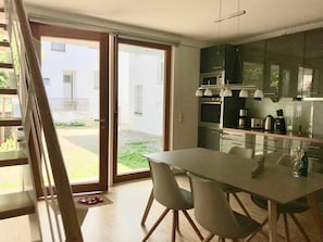 Cozinha moderna com área de refeições, janelas amplas e vista para o exterior.