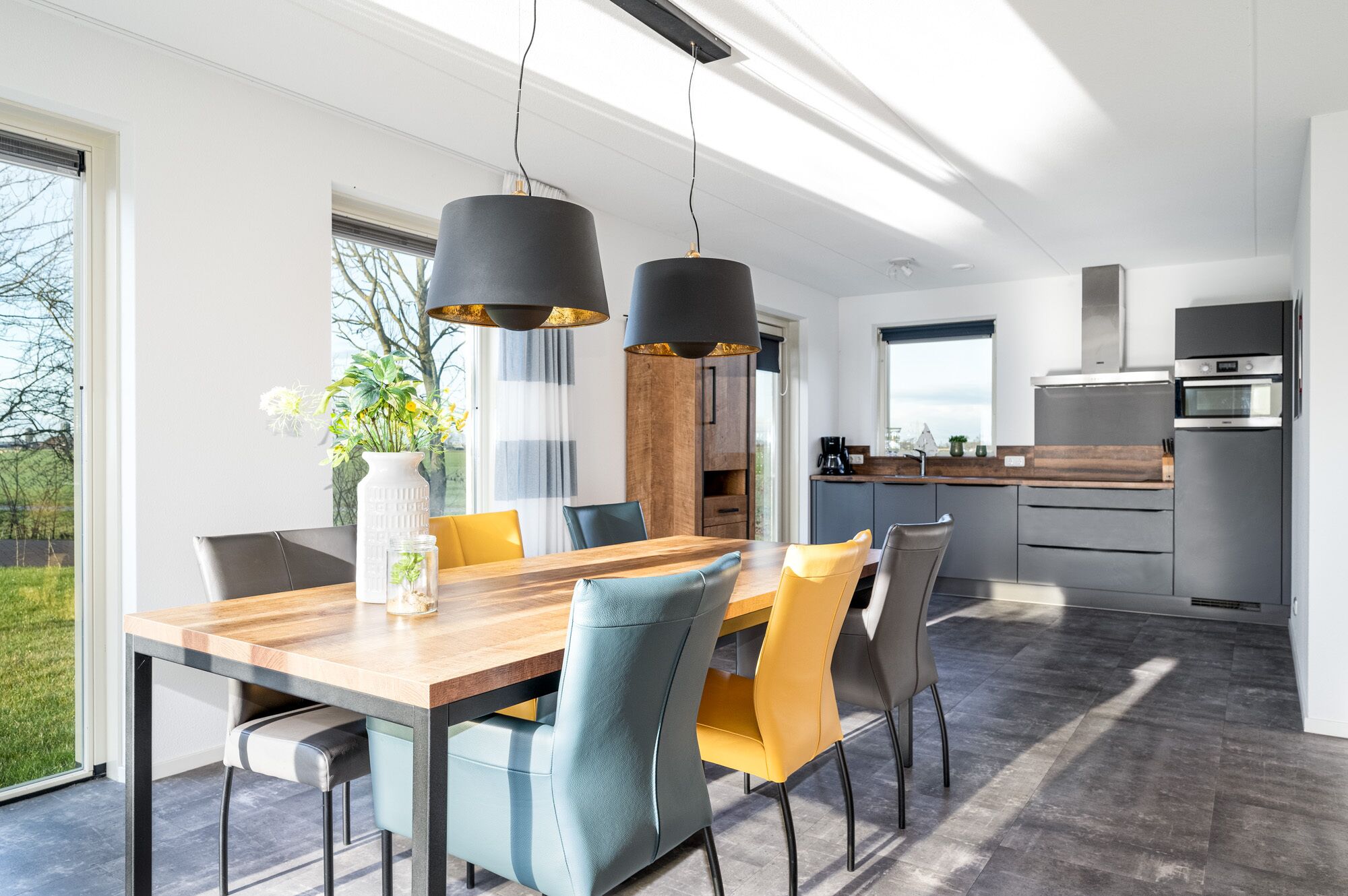 A modern kitchen with a built-in oven and a stainless steel refrigerator.