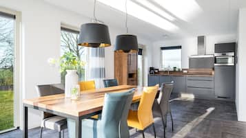 A modern kitchen with a built-in oven and a stainless steel refrigerator.