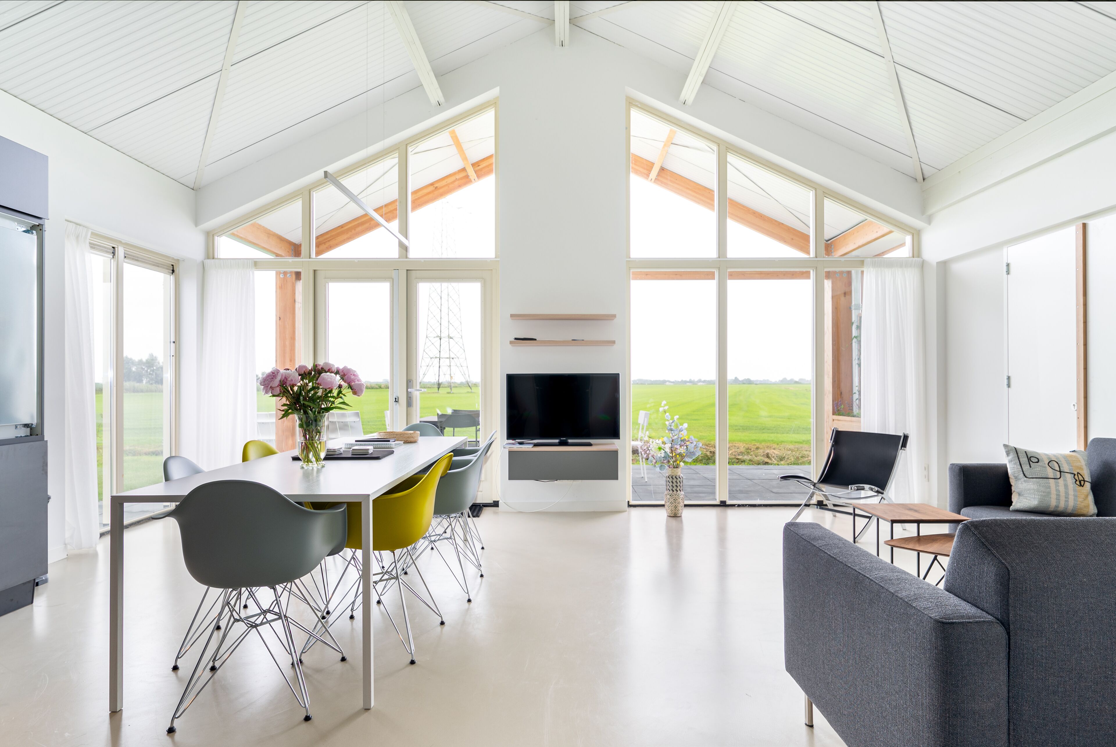 A spacious living area with a large TV, dining table, and seating.