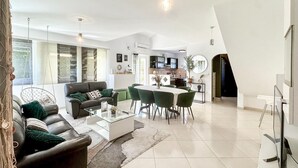 Un salon moderne avec un canapé, une table basse et un coin repas.