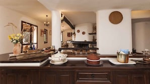 Une cuisine avec un plan de travail en bois foncé, un vase rempli de fleurs et une étagère en pierre rustique.