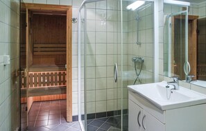 A modern bathroom with a glass shower enclosure, a wooden sauna, and a white sink with a mirror. - Cozy apartment in Hemsedal with sauna (Hemsedal)