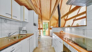 A modern kitchen with white cabinets, a Bosch dishwasher, wooden countertops, and a herringbone tile floor. - Lovely home in Ulfborg with WiFi (Ulfborg)