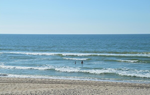 A beach with waves and two people in the water. - Awesome home in Ringkøbing with sauna (Ringkøbing)