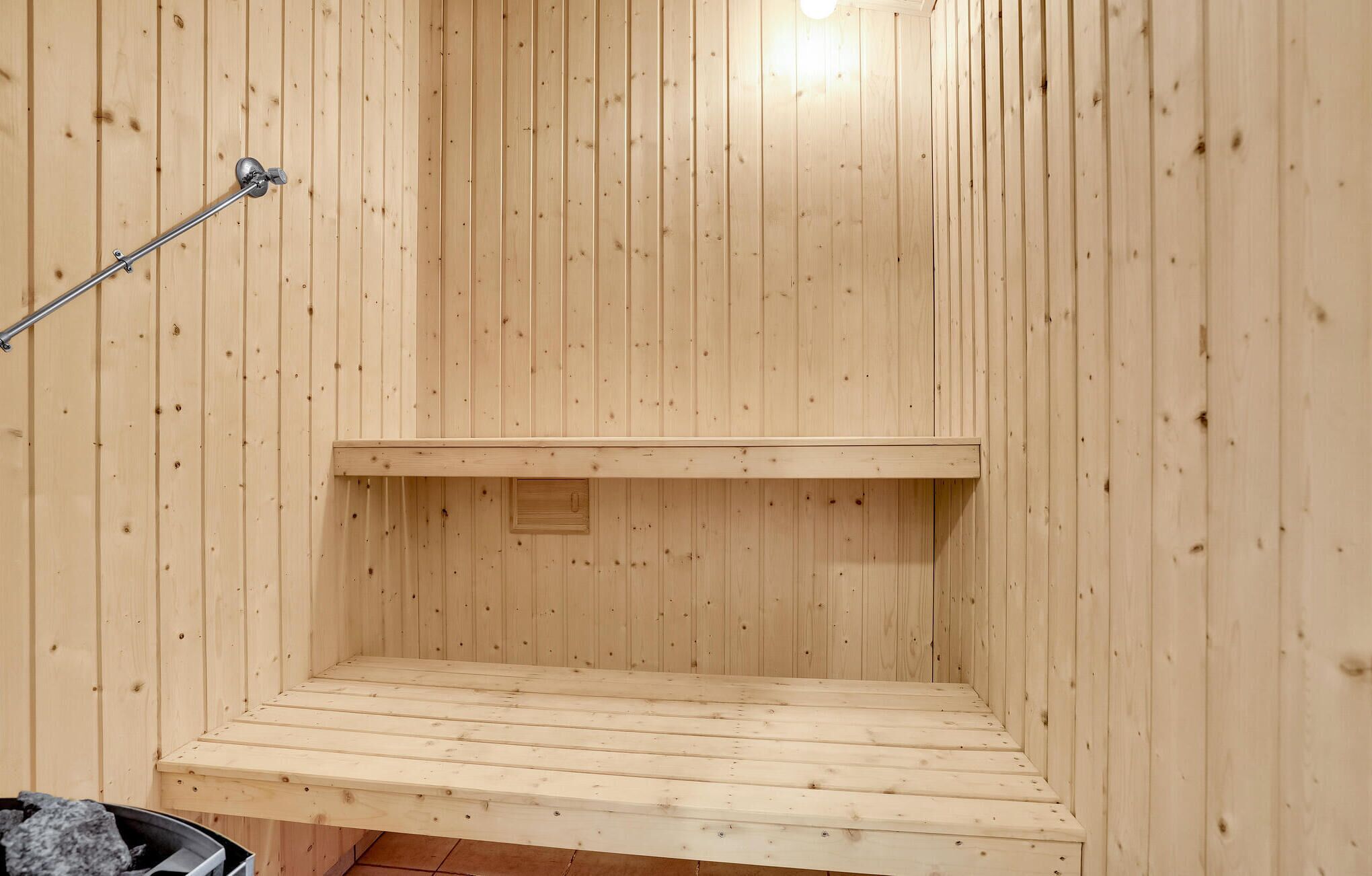 A sauna with wooden walls and a bench.