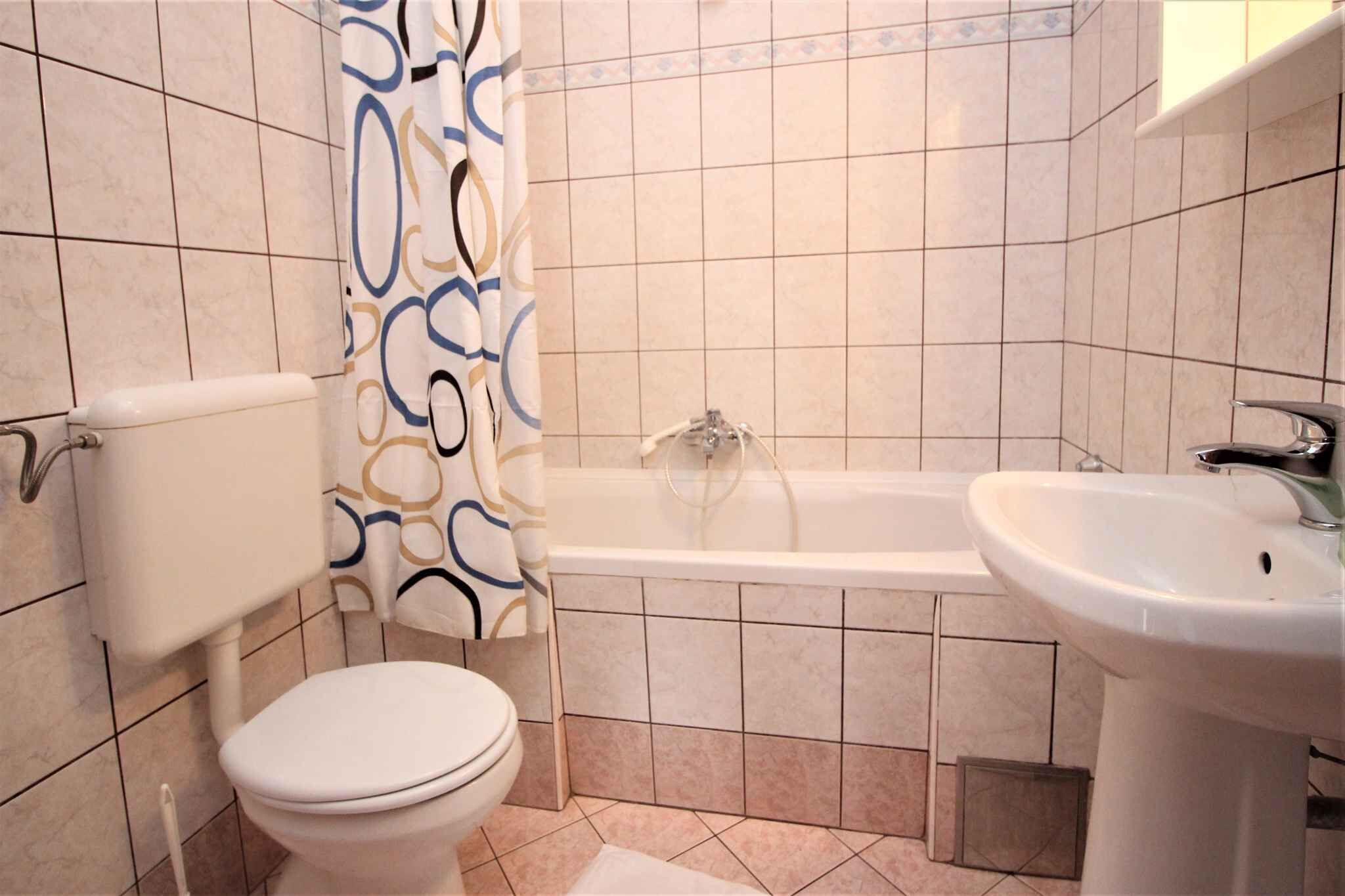 A bathroom with a toilet, bathtub, and sink.